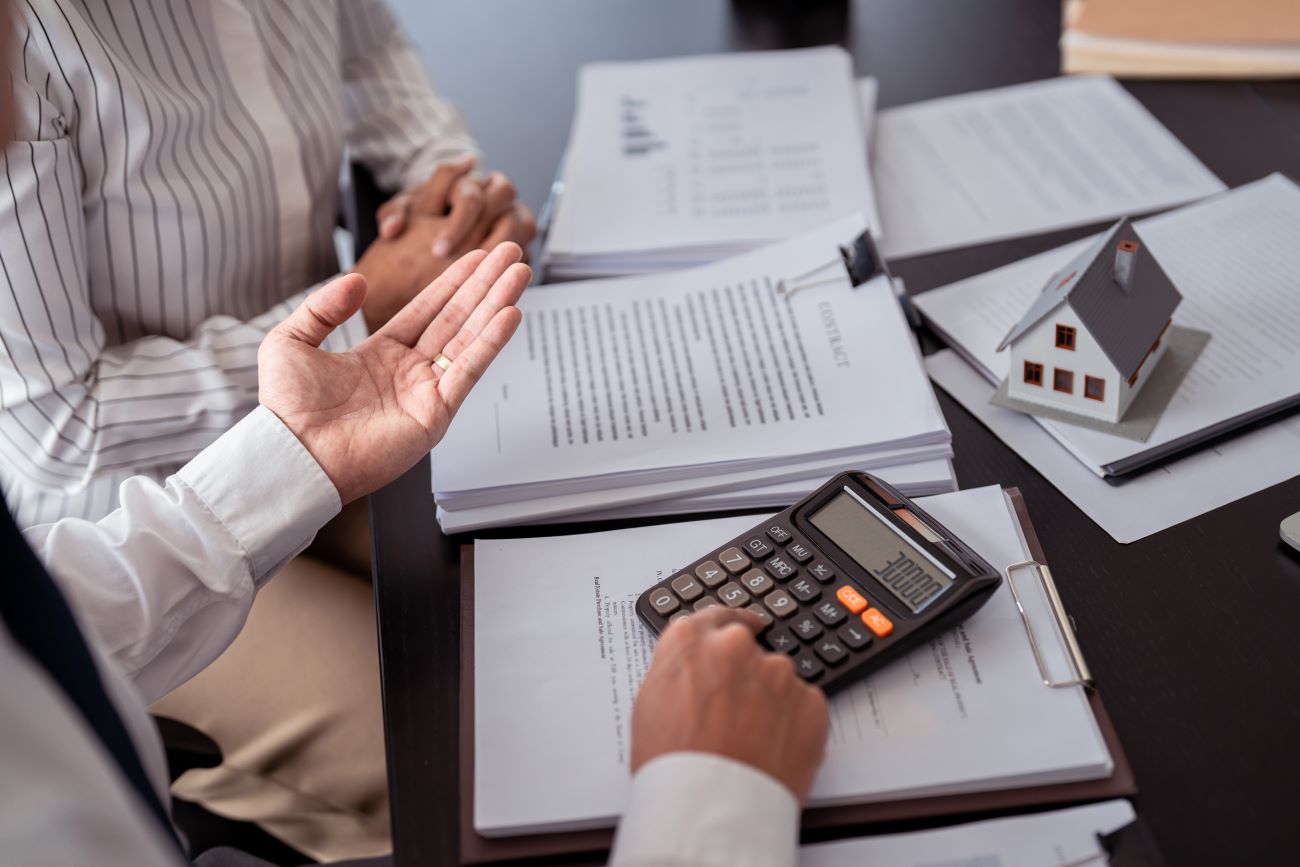 Dois homens executivos conversando e fazendo cálculos em uma calculadora